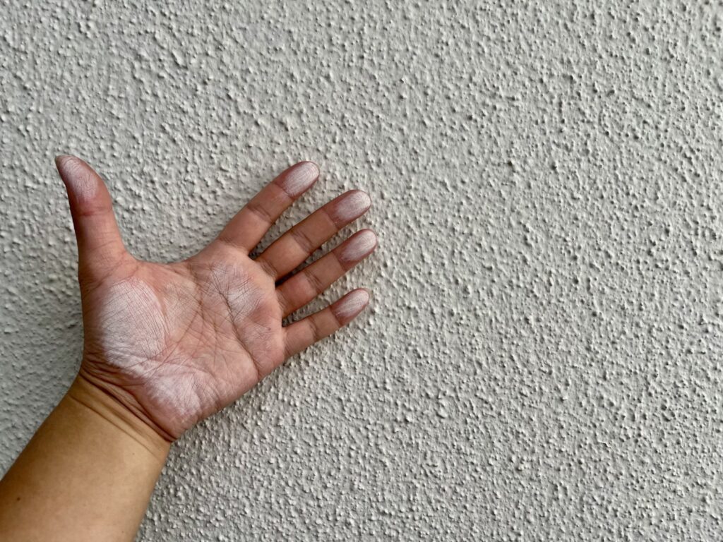 外壁を触って指に付いた白い粉(チョーキング)