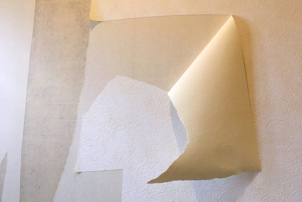 古いクロス（壁紙）をはがす様子
